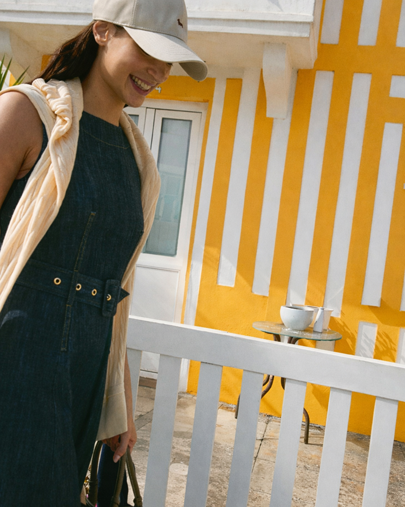 Coppia in spiaggia con polo a righe e cappellini da baseball